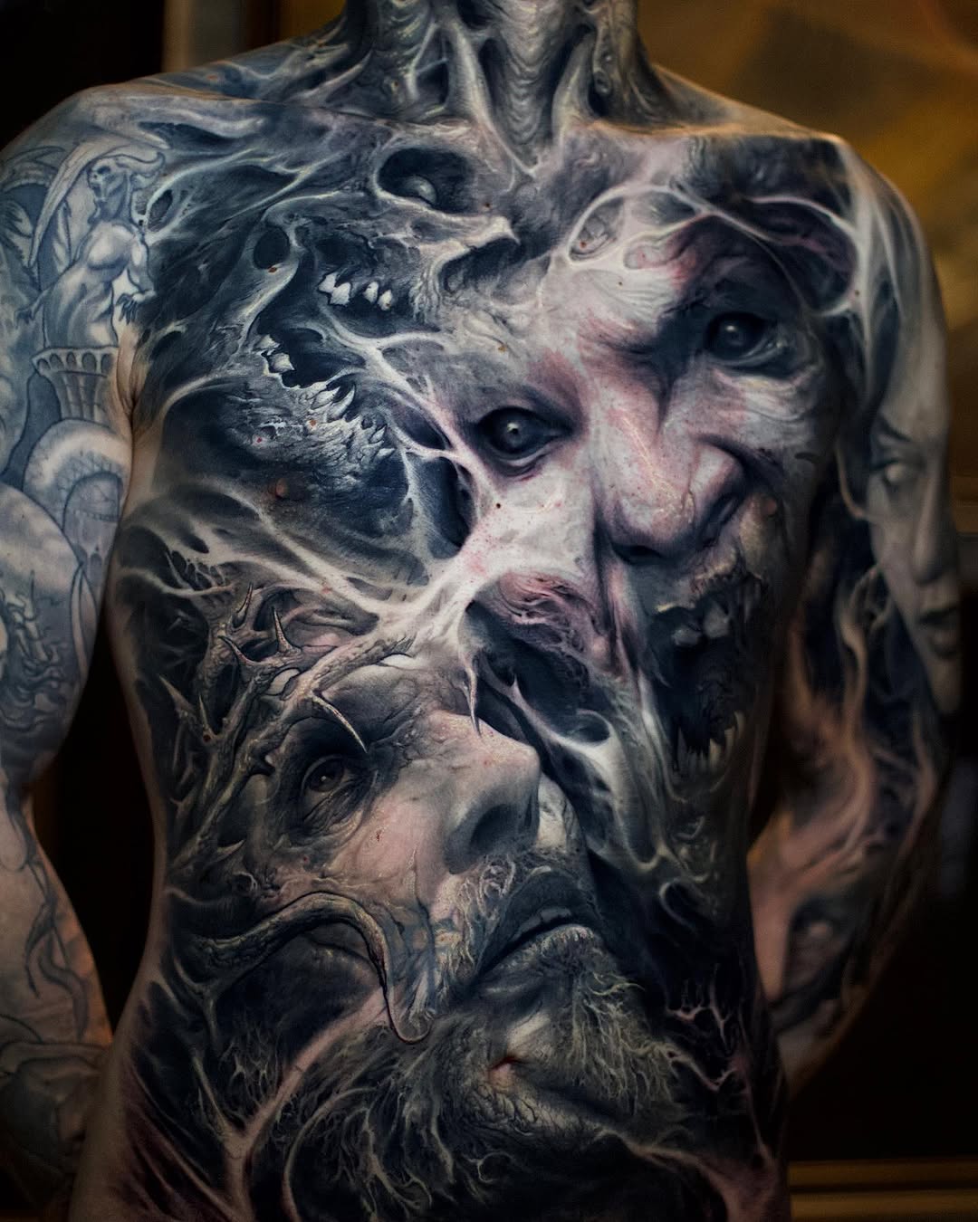 Surreal faces and figures dark art tattoo on the chest by David Jorquera