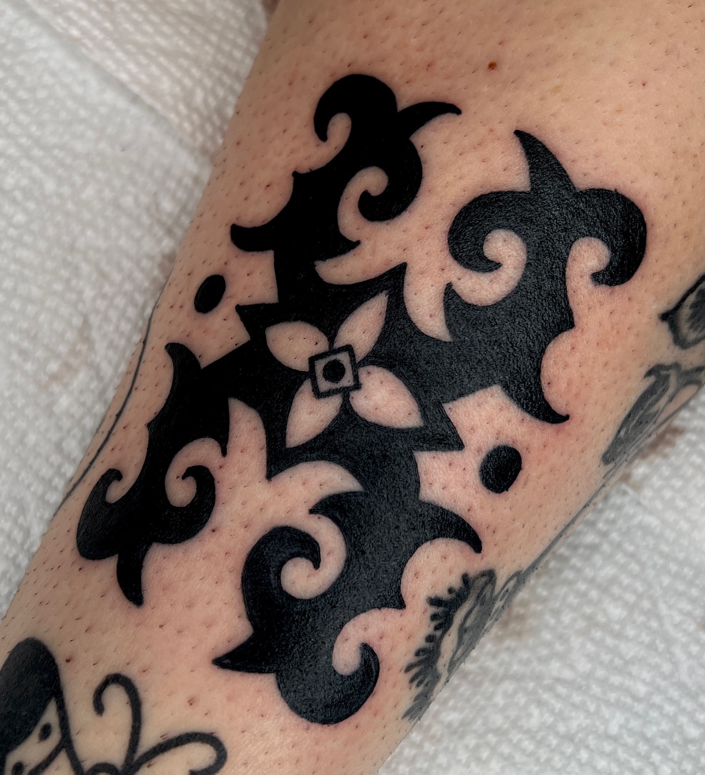 Scrollwork black and grey tattoo on the forearm by Ian Jett