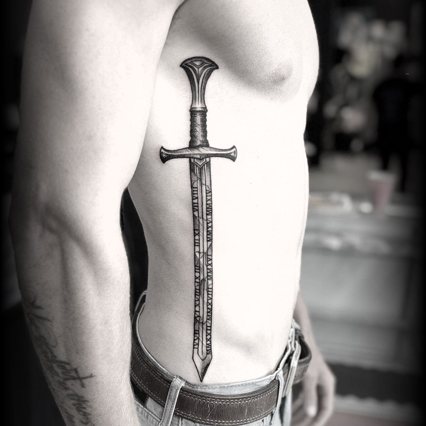 Sword black and grey tattoo on the ribs by Steve