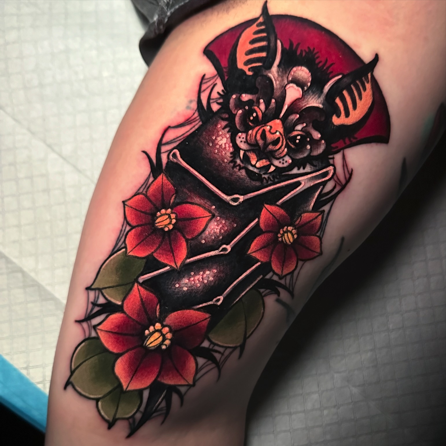 Bat and flowers American traditional tattoo on the thigh by gillian marie
