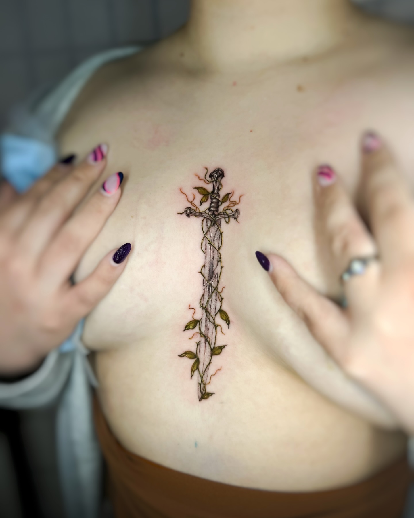 Sword with vines neo-traditional tattoo on the chest by Natasha Rachel Fineline Tattoos Nashville