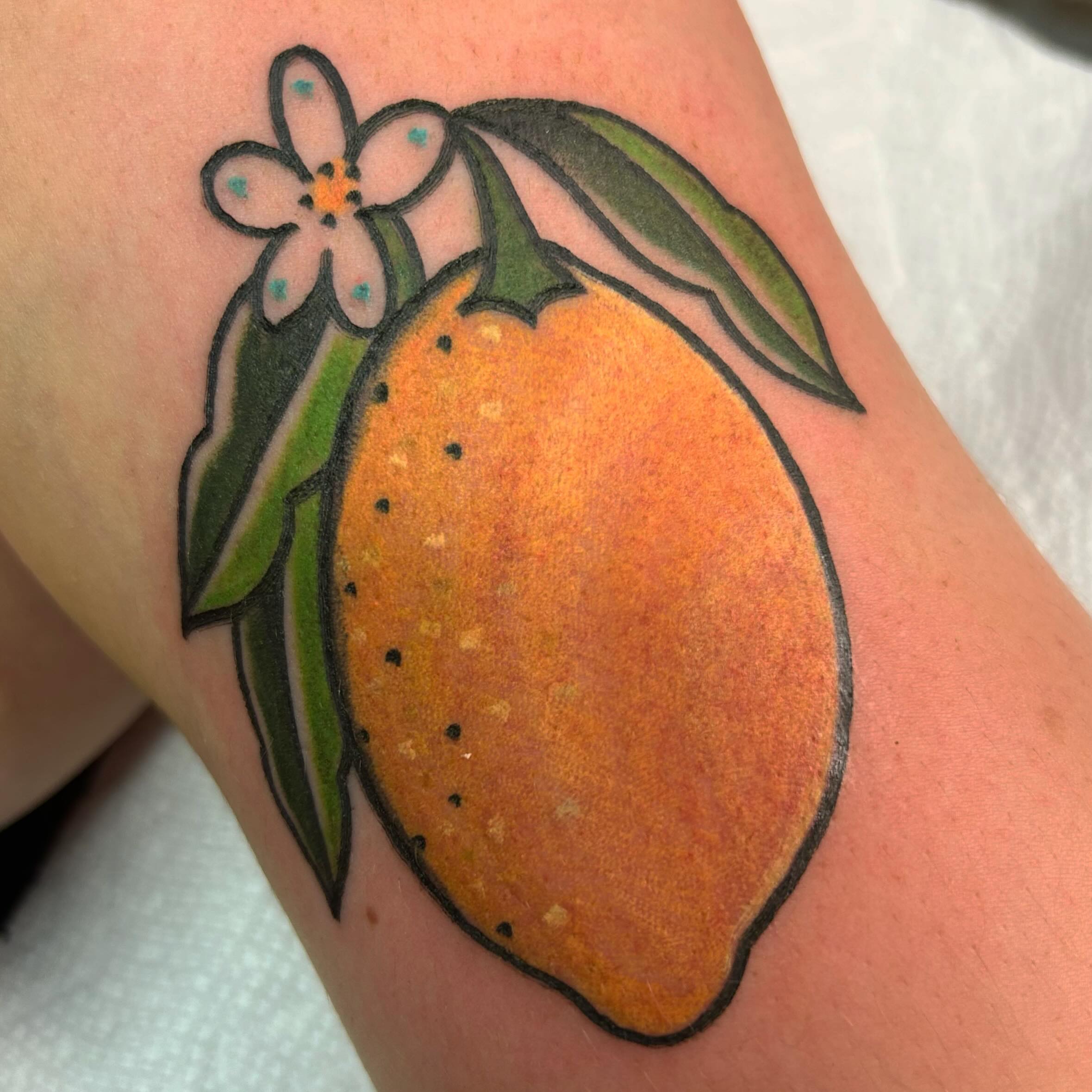 Orange with flower dotwork tattoo on the forearm by Lauren Caldwell 🔮🌙