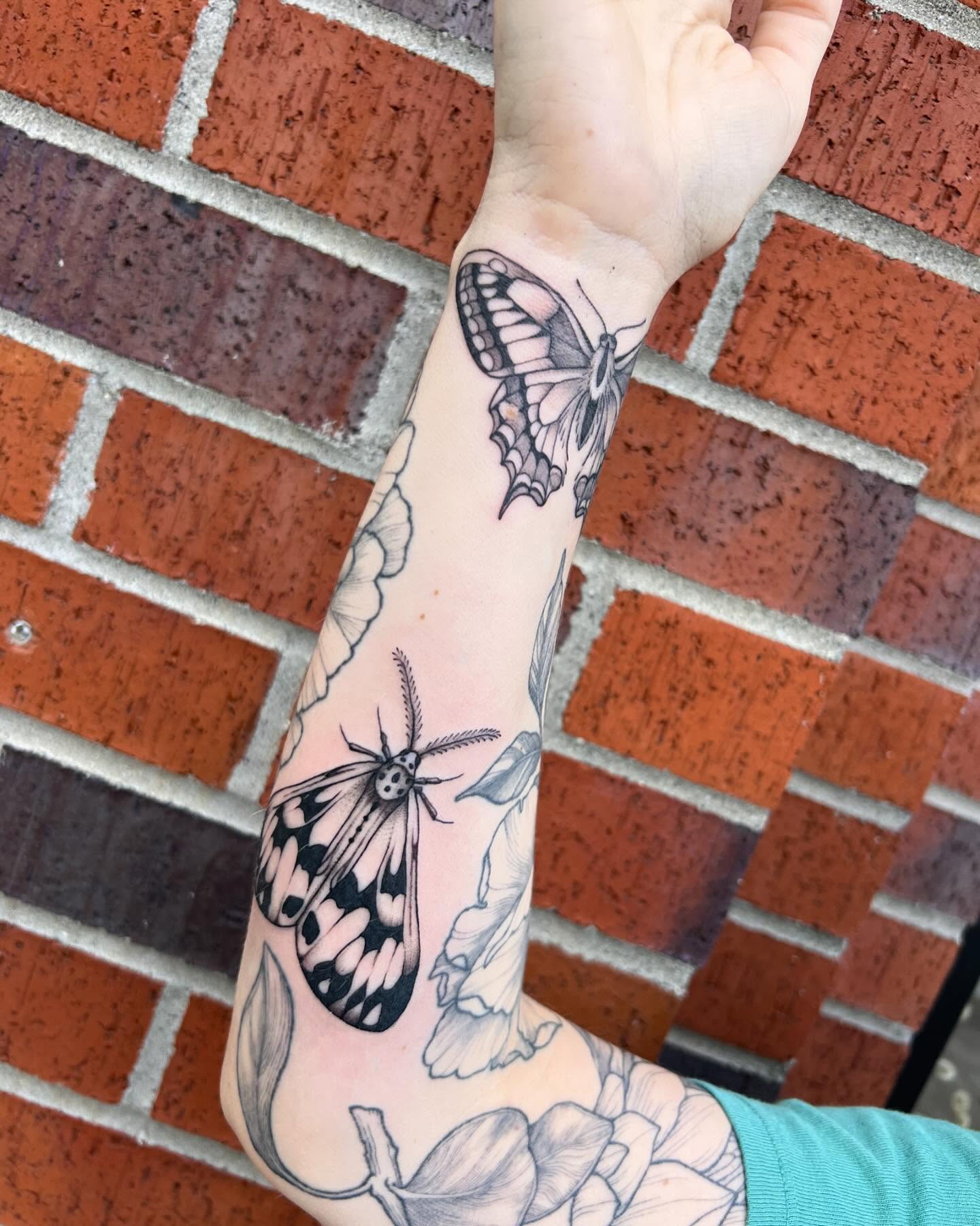Butterflies and flowers black and grey tattoo on the forearm by Tasha Venola, Bellingham, Washington