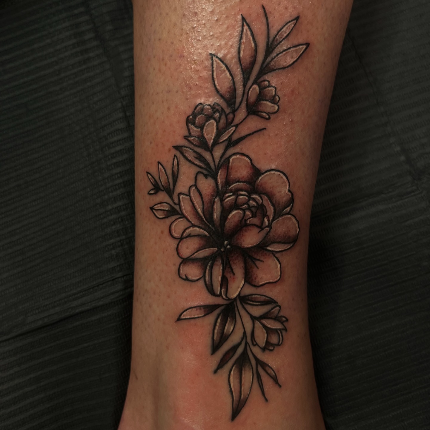 Peony and leaves black and grey tattoo on the forearm by Therapy ink