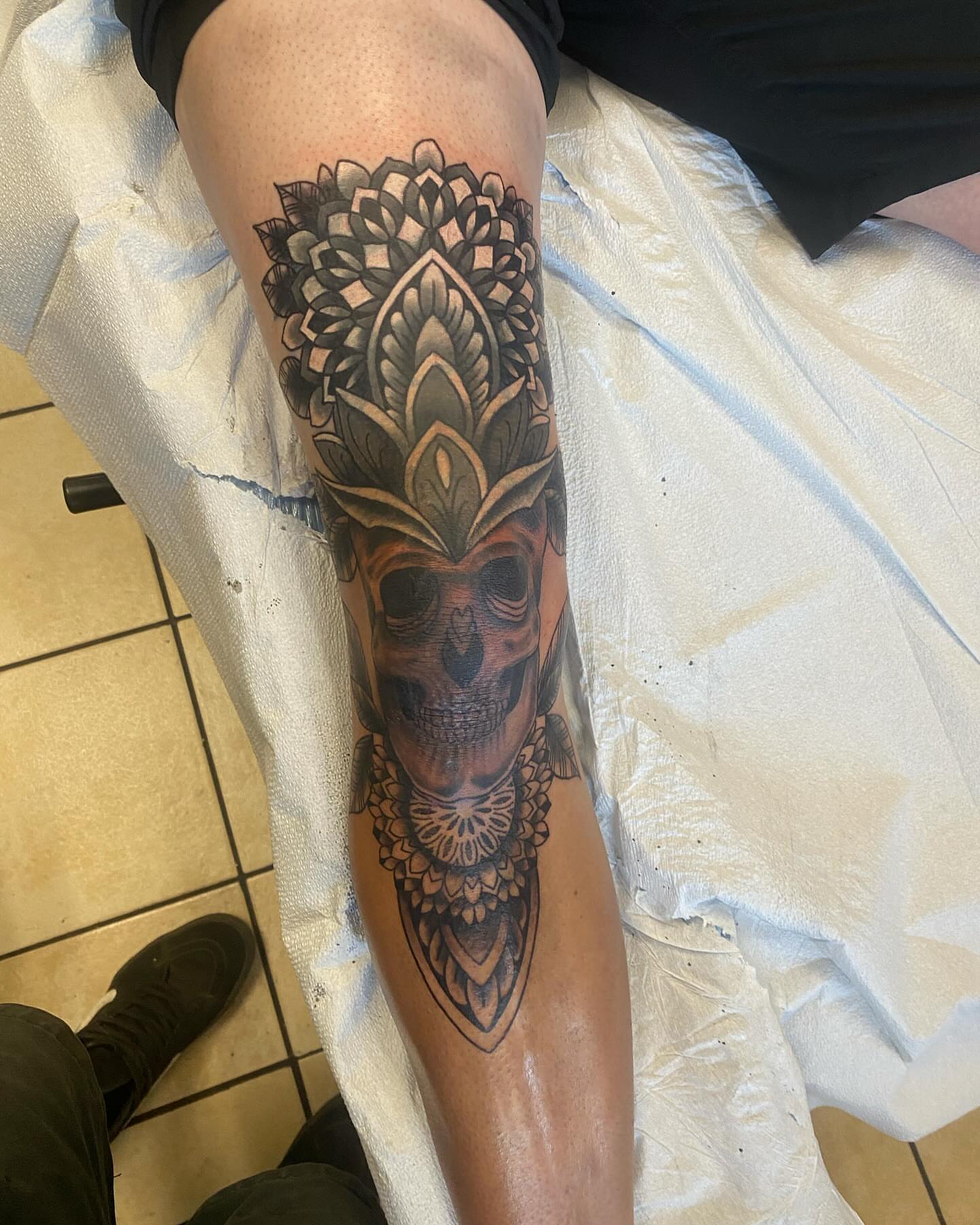Skull with ornamental headdress geometric tattoo on the leg by Nicholas Jones