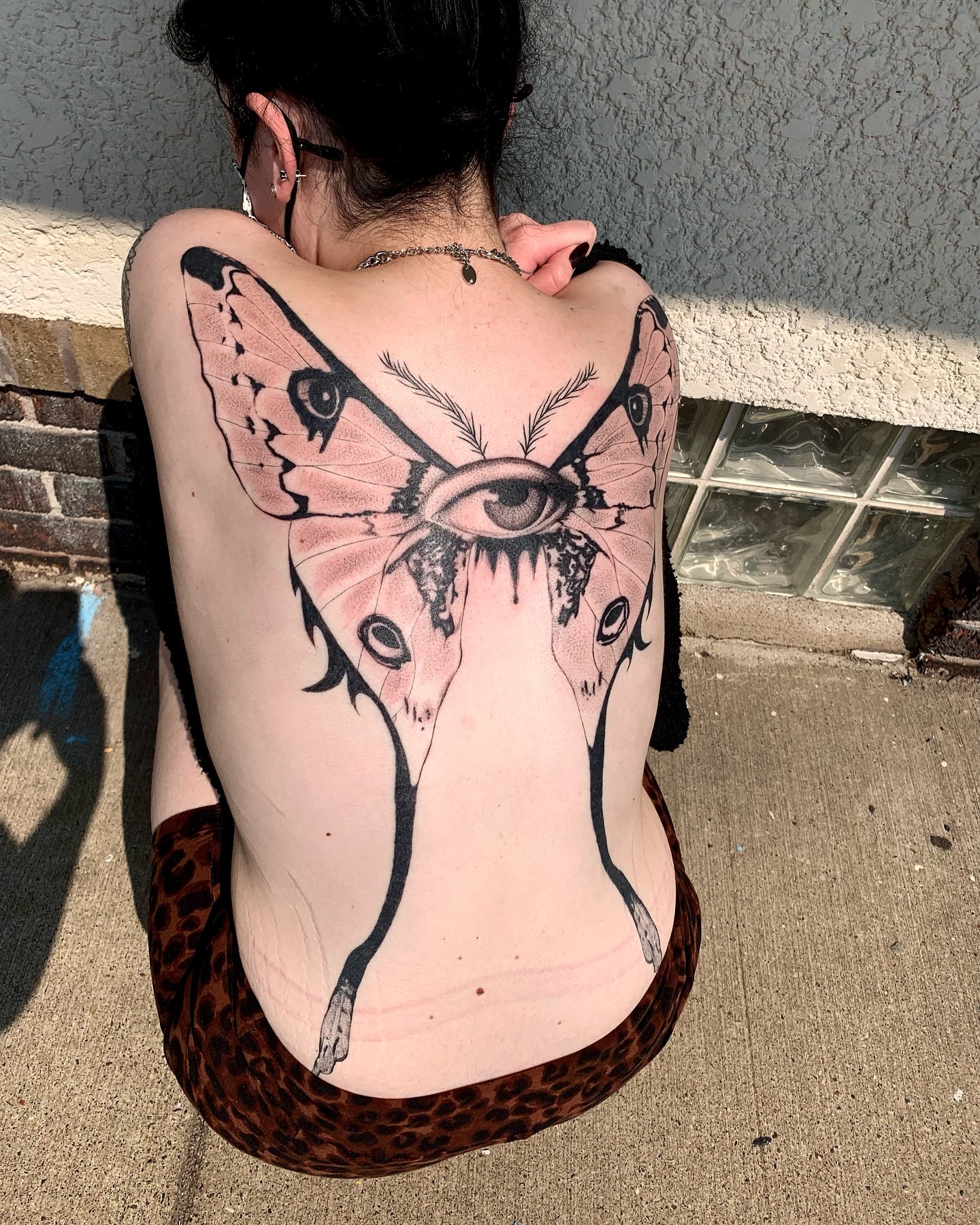 Eye and butterfly realism tattoo on the back by Maddy Paige