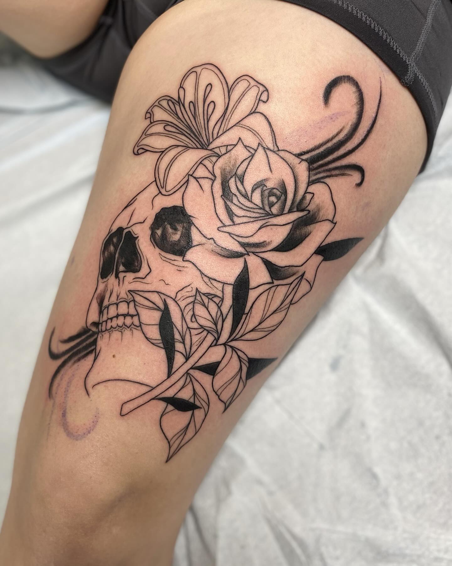 Skull and flowers realism tattoo on the thigh by Taya Lynn, Hudson, Wisconsin