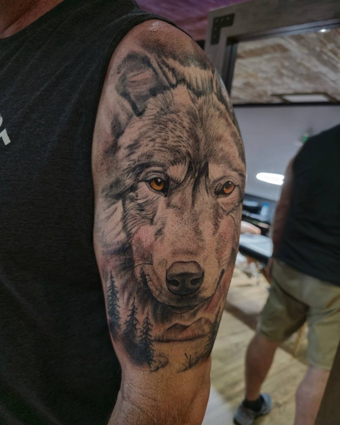 Wolf realism tattoo on the upper arm by Cody Lambert