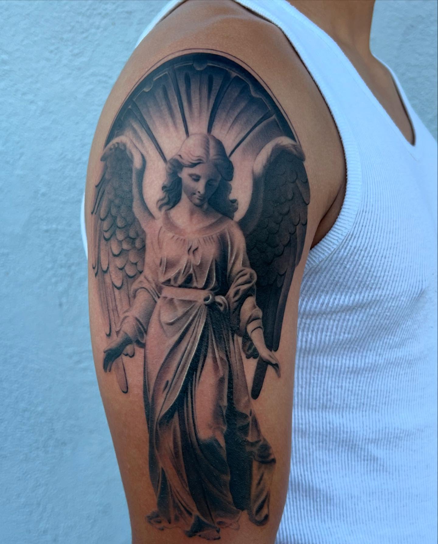 Angel realism tattoo on the upper arm by Thomas Conard