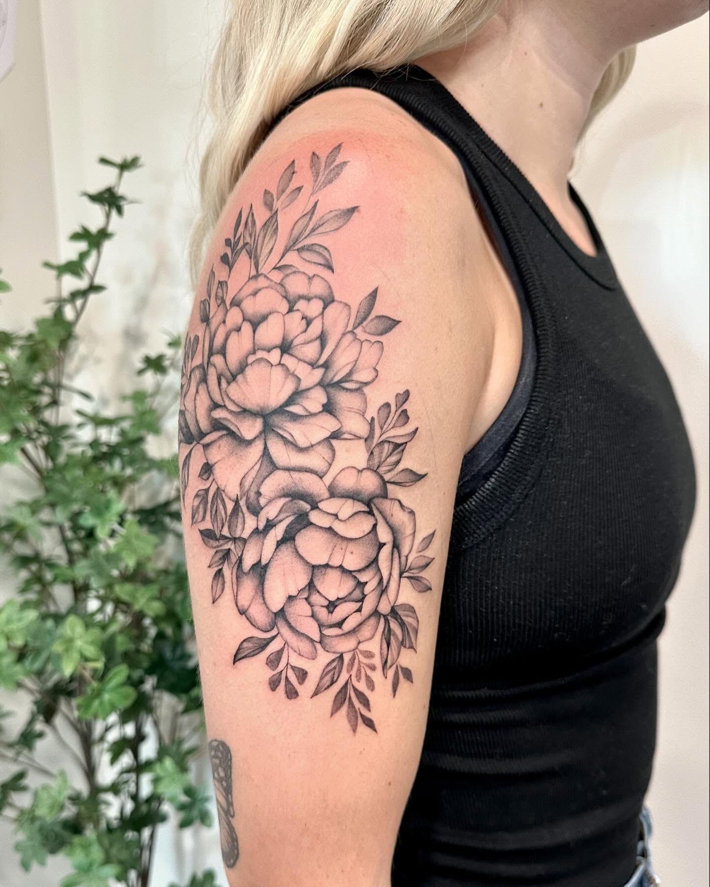 Peony bouquet black and grey tattoo on the upper arm by Kate Darling