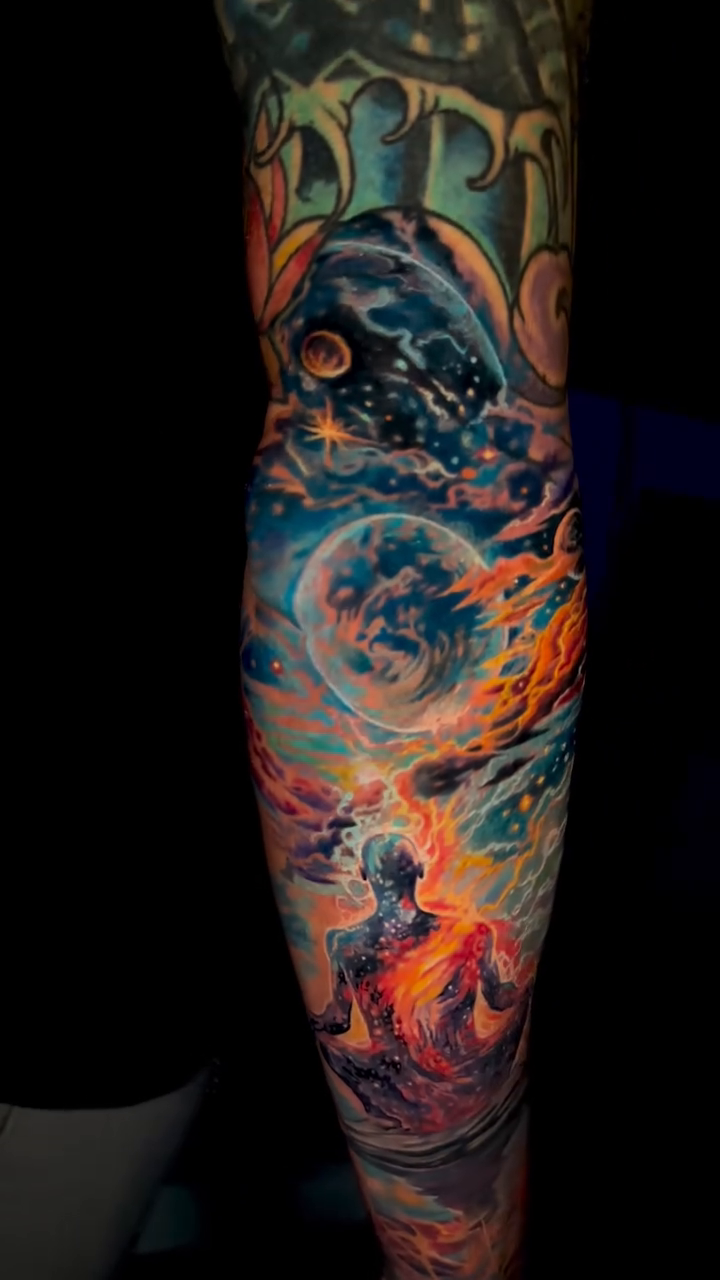 Cosmic scene with meditating figure realism tattoo by James Moyer