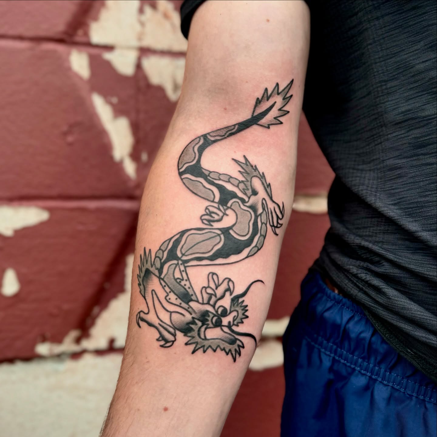 Dragon black and grey tattoo on the forearm by Mazie