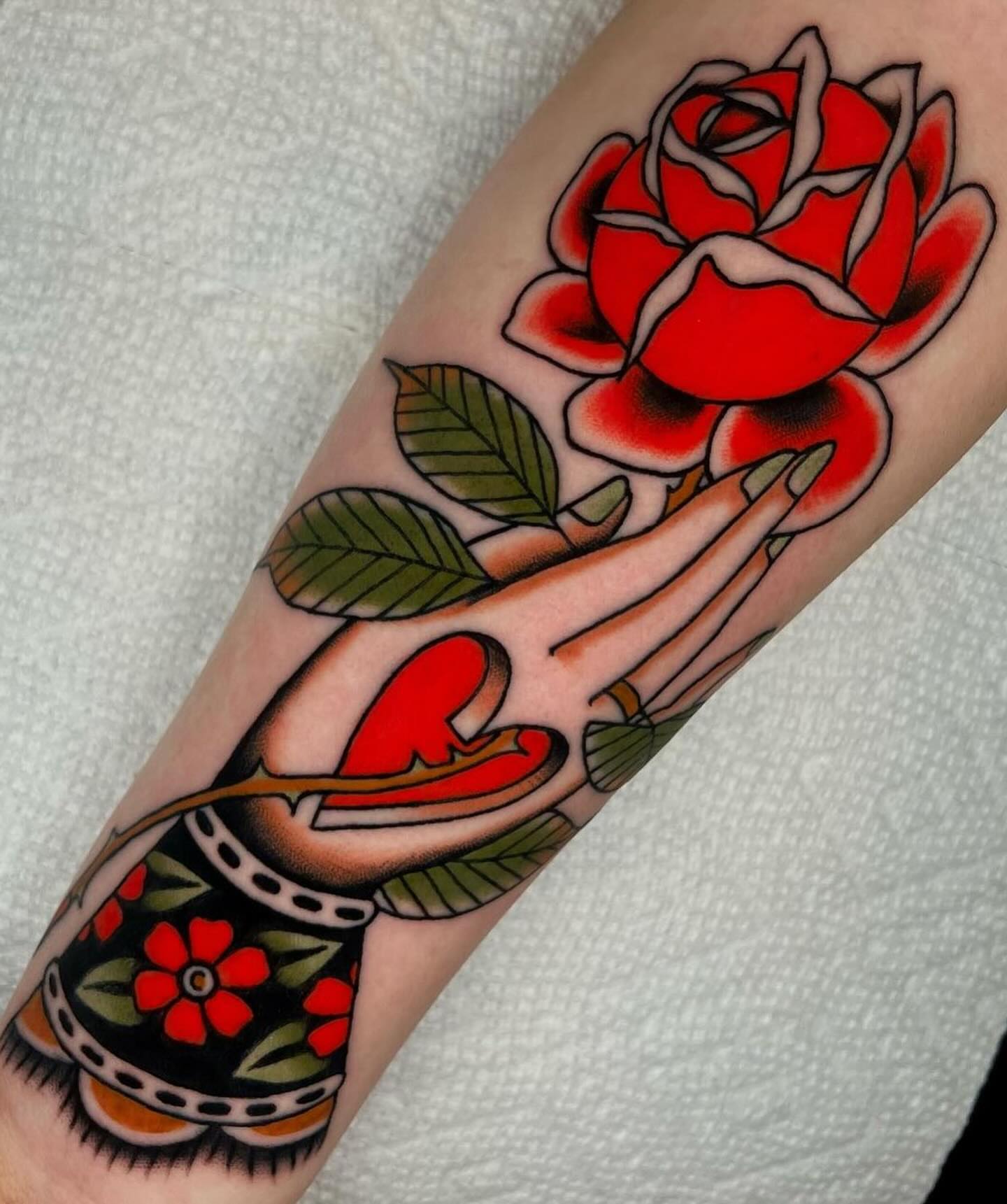 Praying hands with rose American traditional tattoo on the forearm by Hailey Johnson