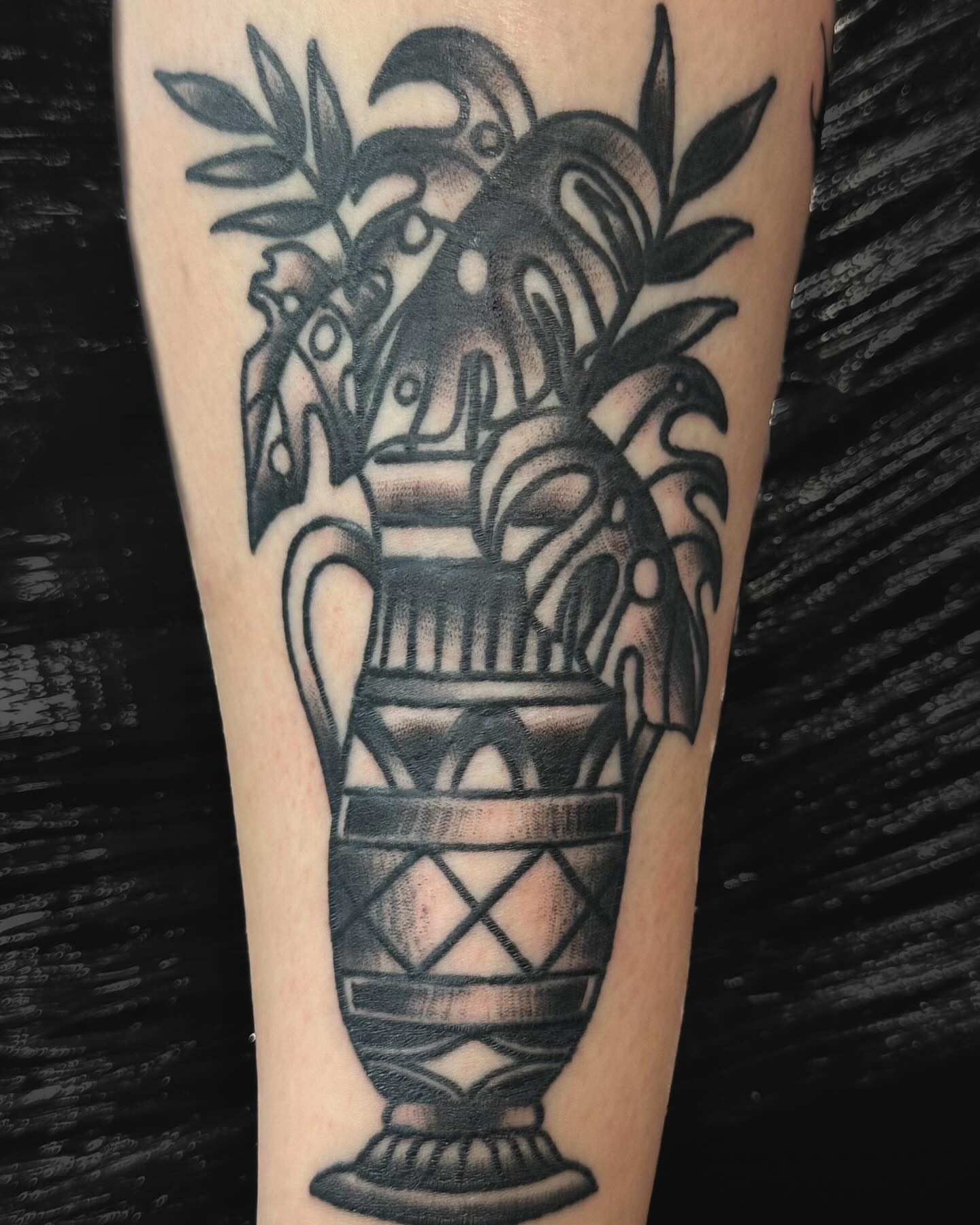 Ancient vase with foliage black and grey tattoo on the forearm by Zach Eden