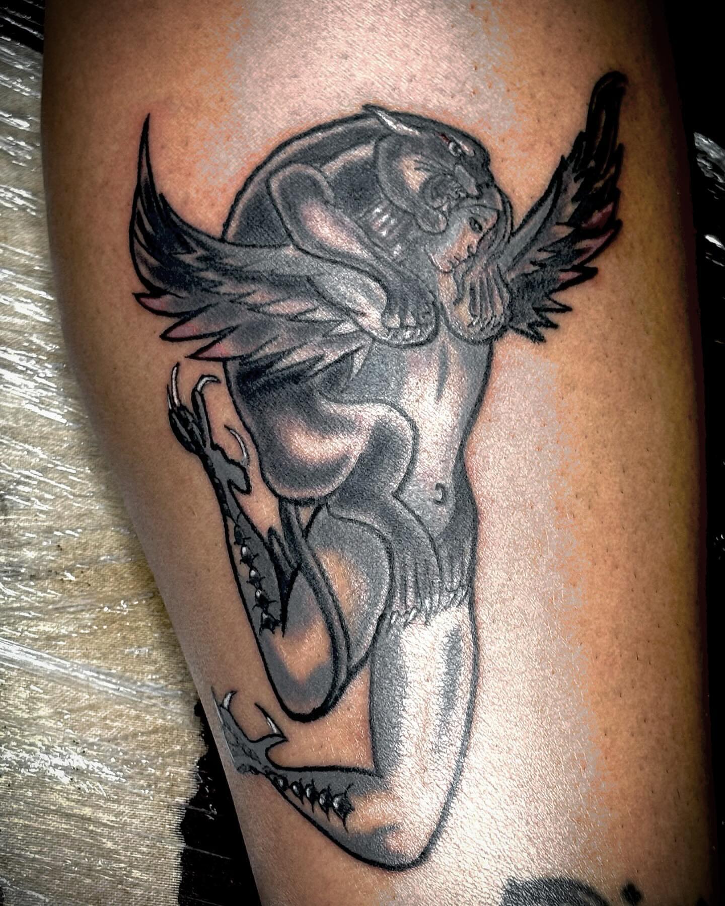 Winged creature black and grey tattoo on the thigh by Bobby Glennon