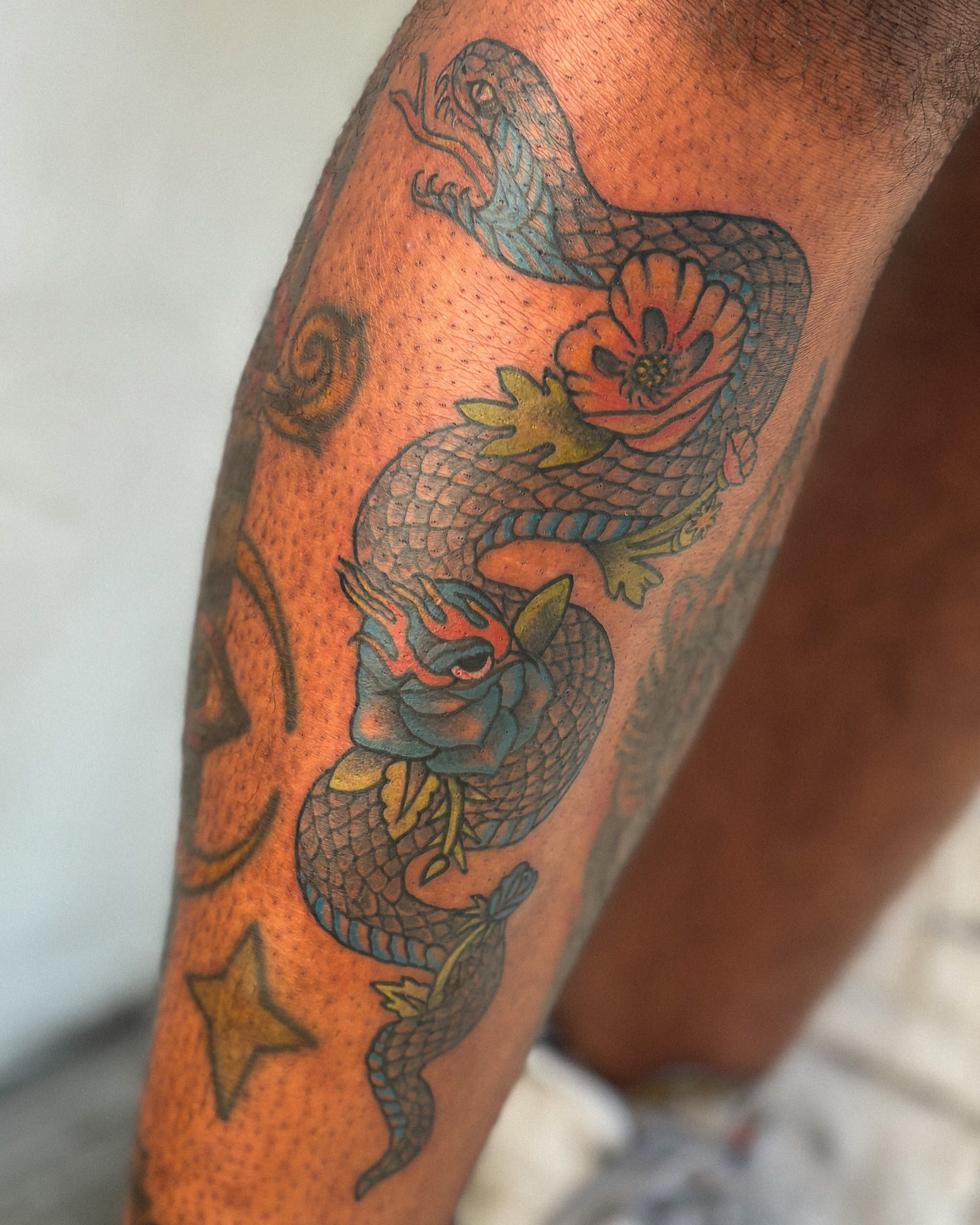 Snake and peony American traditional tattoo on the forearm by Katelyn Spence