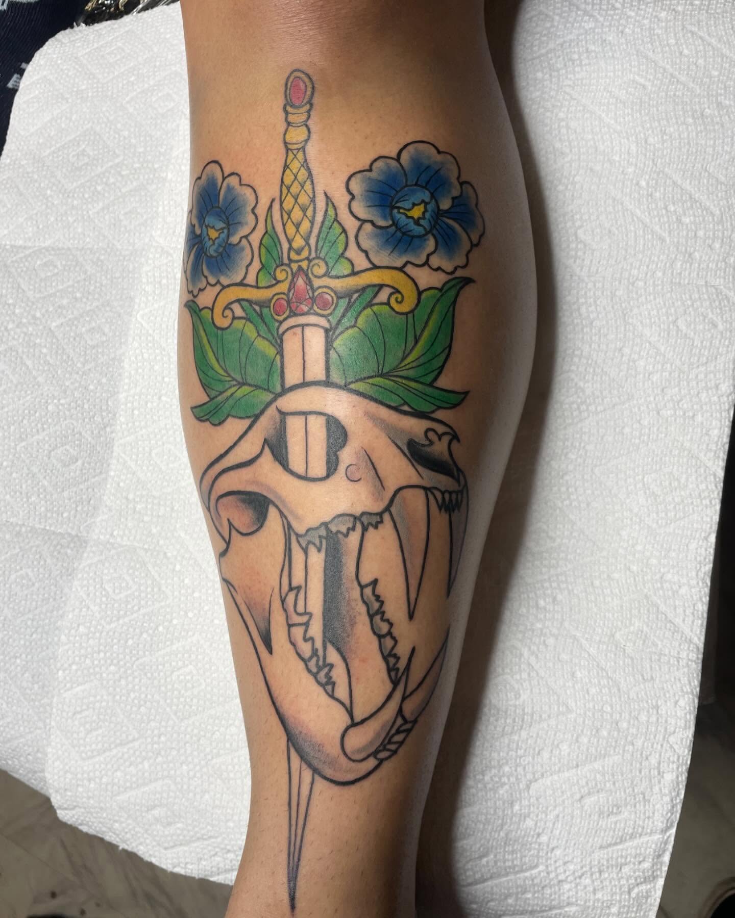 Skull and dagger with flowers American traditional tattoo on the forearm by Michelle
