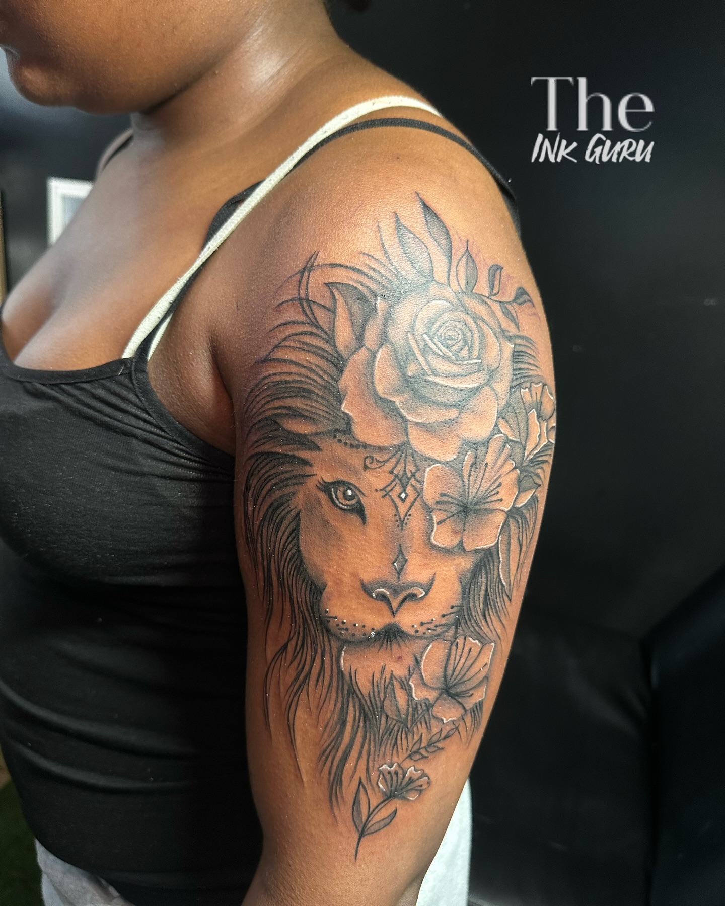 Lion and flowers realism tattoo on the shoulder by The Ink Guru.
