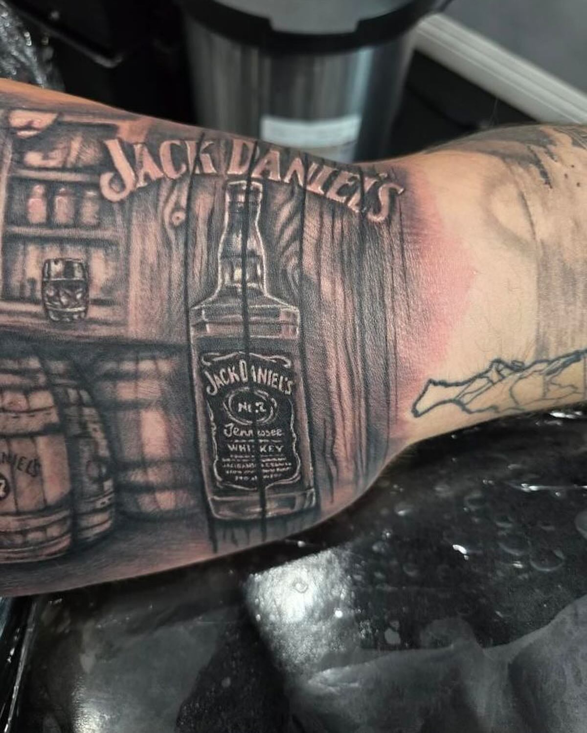 Jack daniels bottle black and grey tattoo on the forearm by Lissy Red