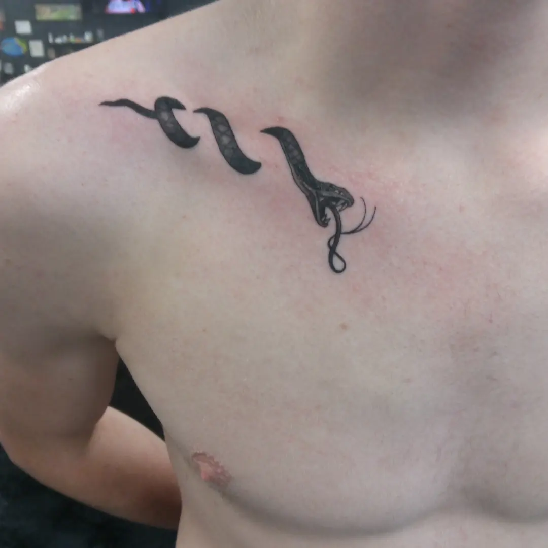 Snake black and grey tattoo on the chest by Cassandra Davis