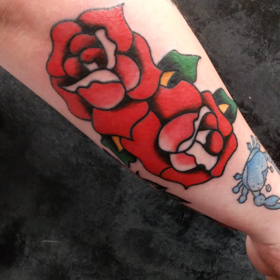 Red rose American traditional tattoo on the forearm by Cassandra Davis