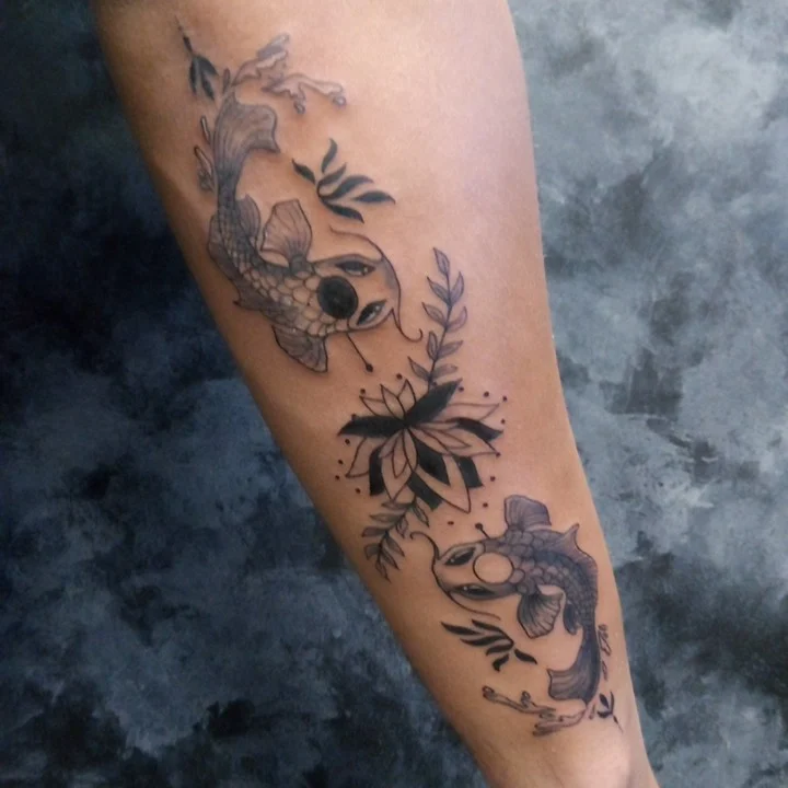 Koi fish and lotus dotwork tattoo on the forearm by Cassandra Davis