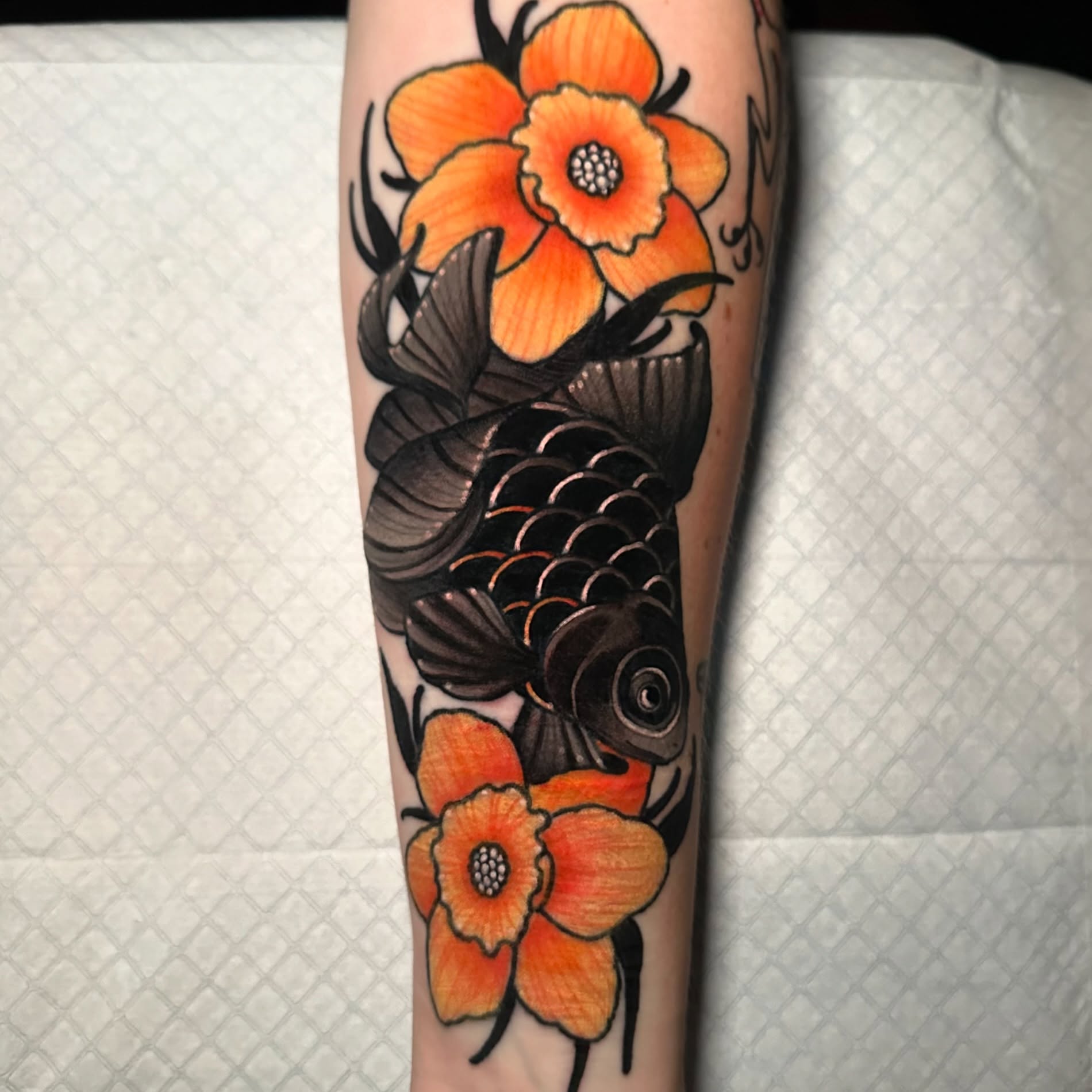 Koi fish and flowers American traditional tattoo on the forearm by gillian marie