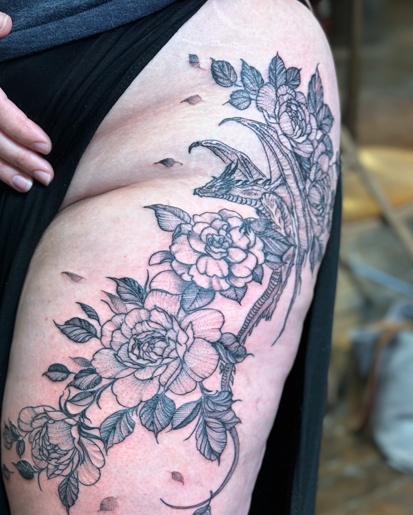 Dragon and roses realism tattoo on the thigh by Benjamin Carlson