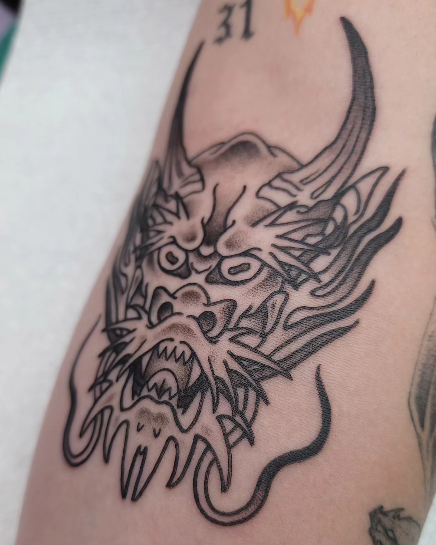 Dragon head black and grey tattoo on the forearm by Ghost