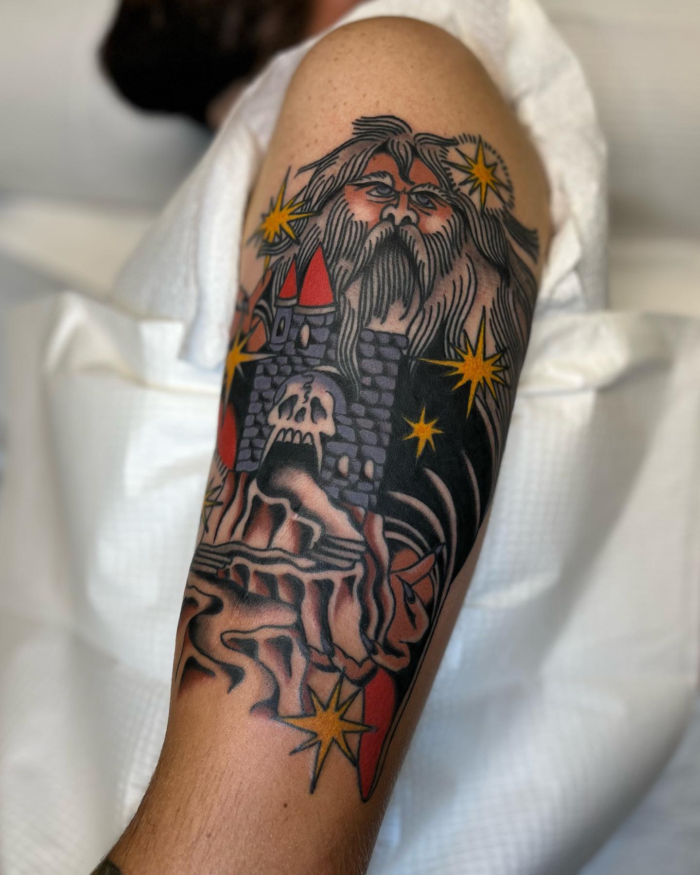 Bearded man with castle American traditional tattoo on the forearm by 🌞all Bodies Welcome🌞