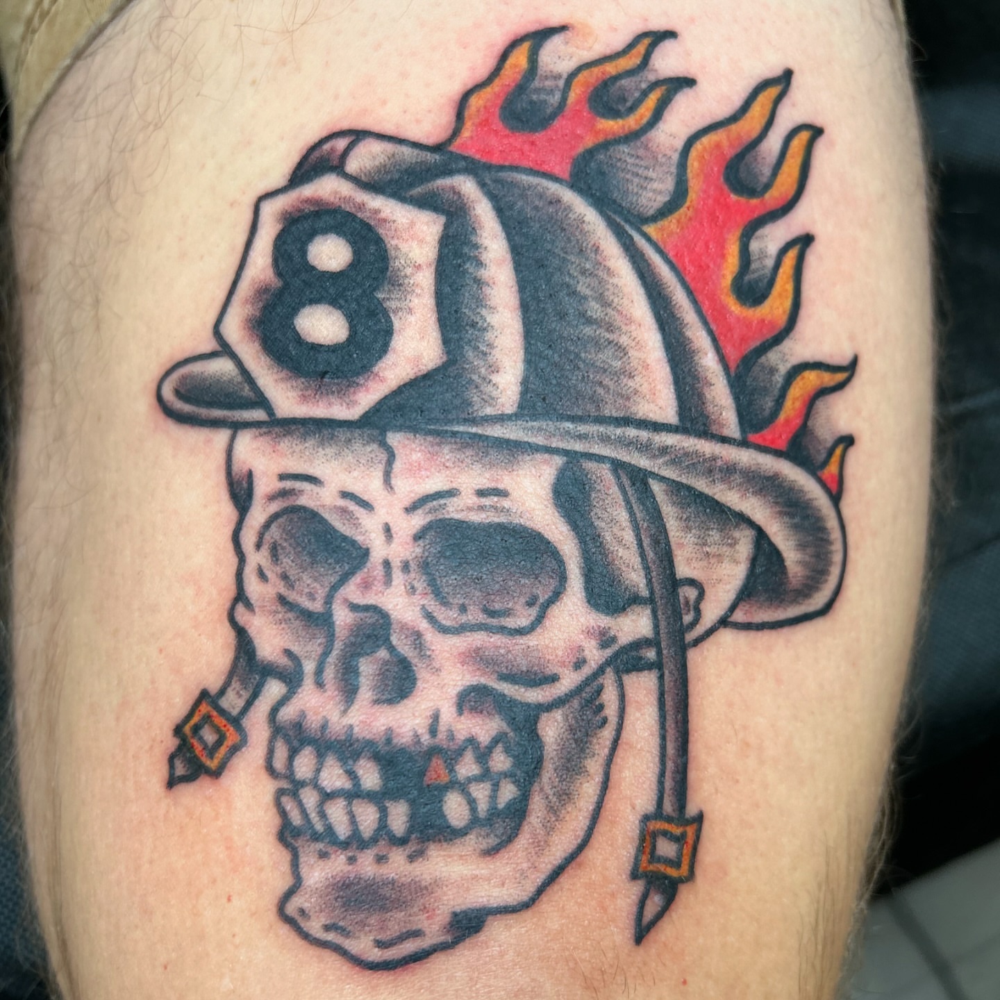 Firefighter helmet with skull American traditional tattoo on the thigh by Alex Fannin