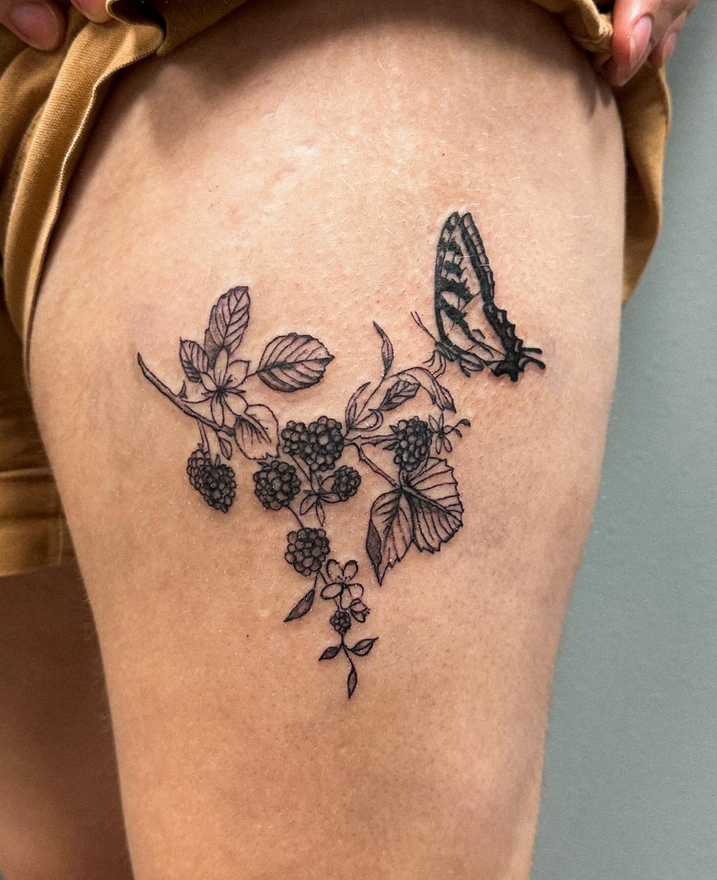 Blackberry branch with butterfly black and grey tattoo on the thigh by Portland Tattoo Artist
