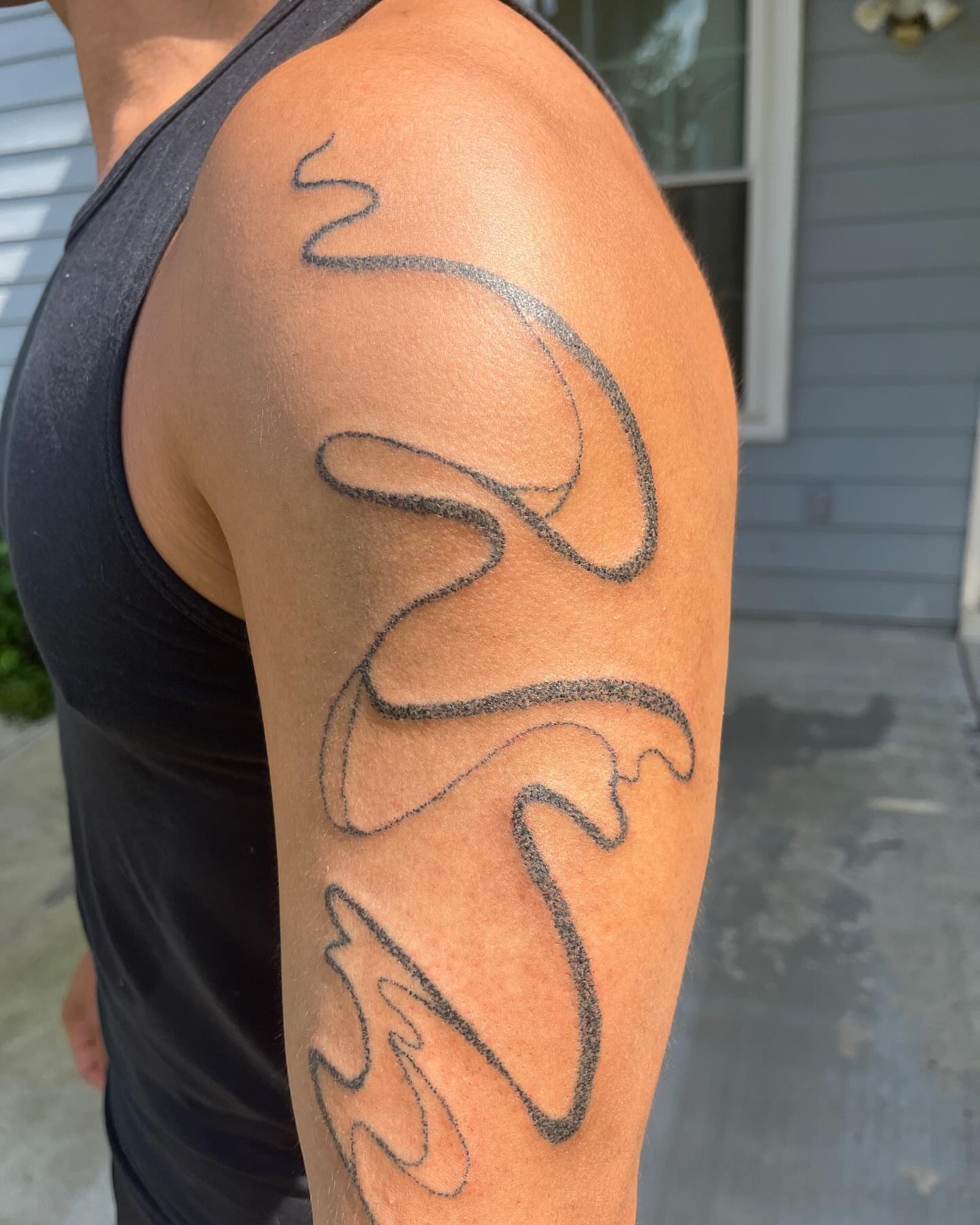 Swirls black and grey tattoo on the upper arm by hana