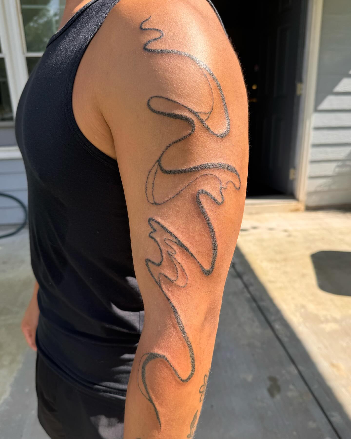 Flame black and grey tattoo on the upper arm by hana