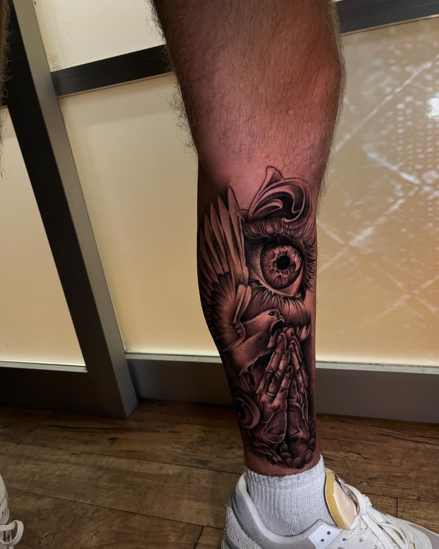 Eye and hands realism tattoo on the calf by Miles Johnson