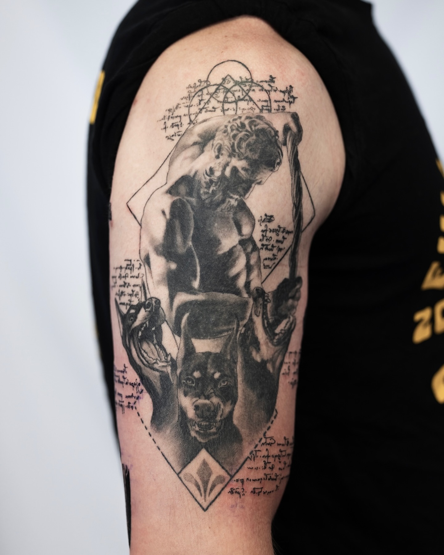 Man and dog realism tattoo on the upper arm by Ben Cisek