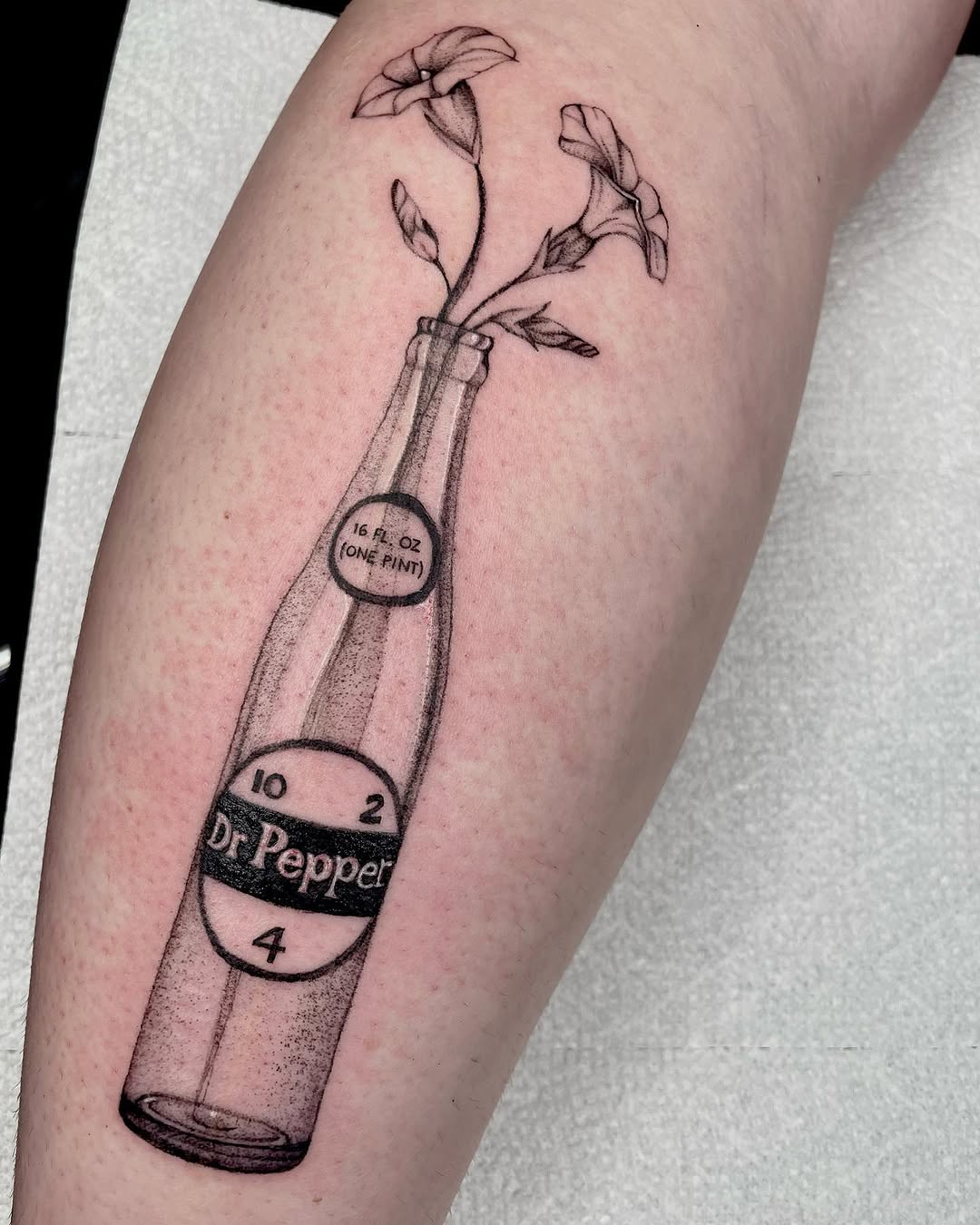 Dr Pepper bottle with flowers sketch tattoo on the forearm by madison, Cincinnati