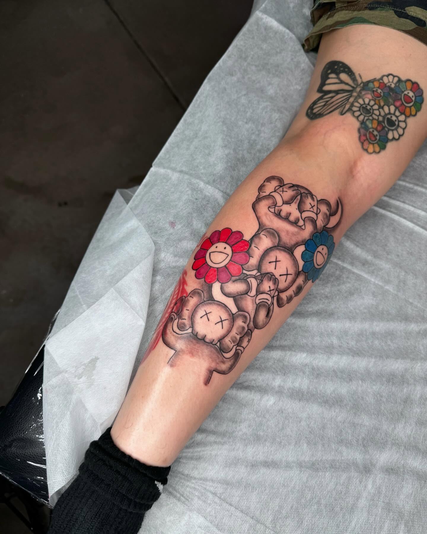 Kaws-inspired characters new school tattoo on the forearm by Sierra 🩷