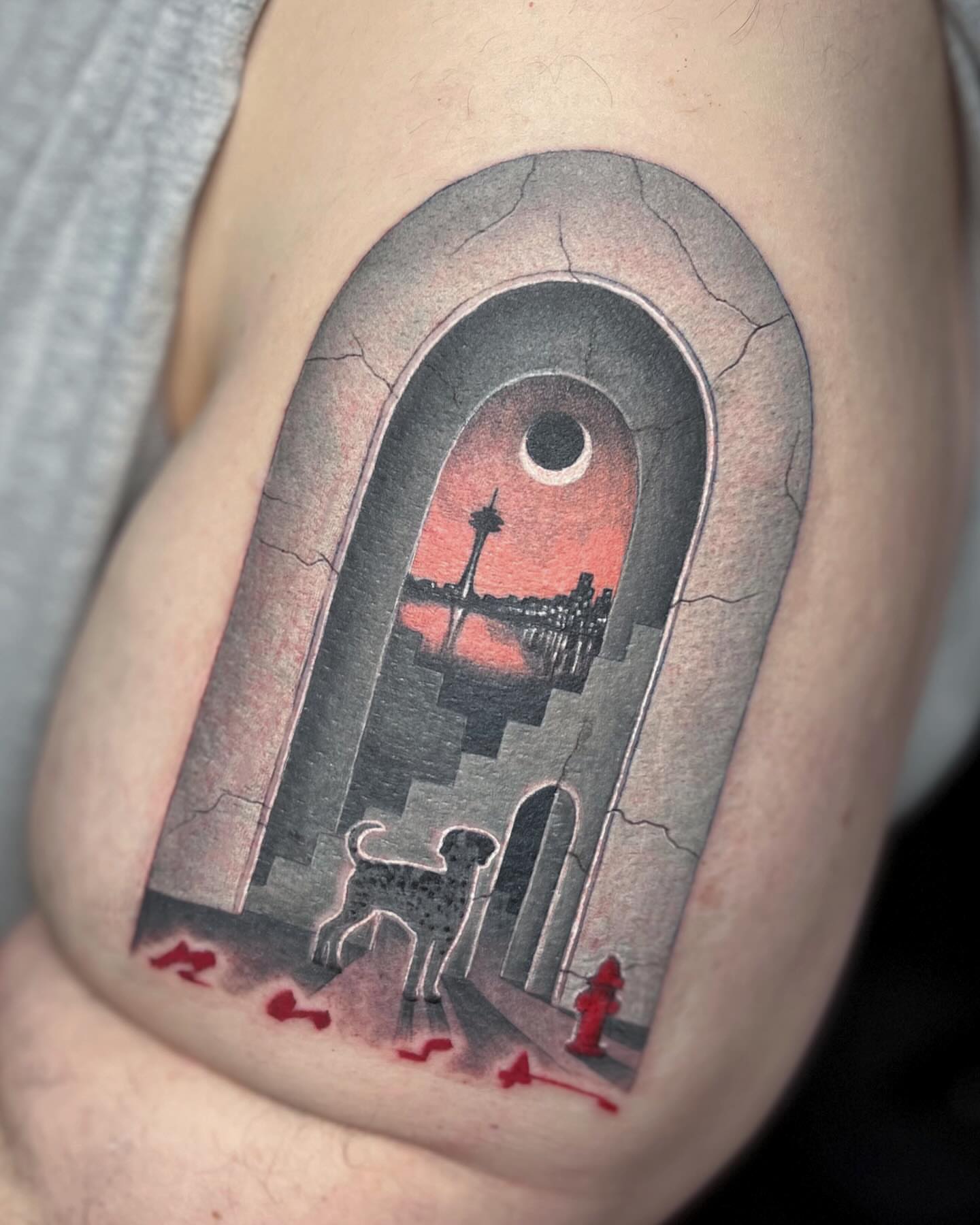 Cityscape with dog realism tattoo on the upper arm by Katlyne Jones