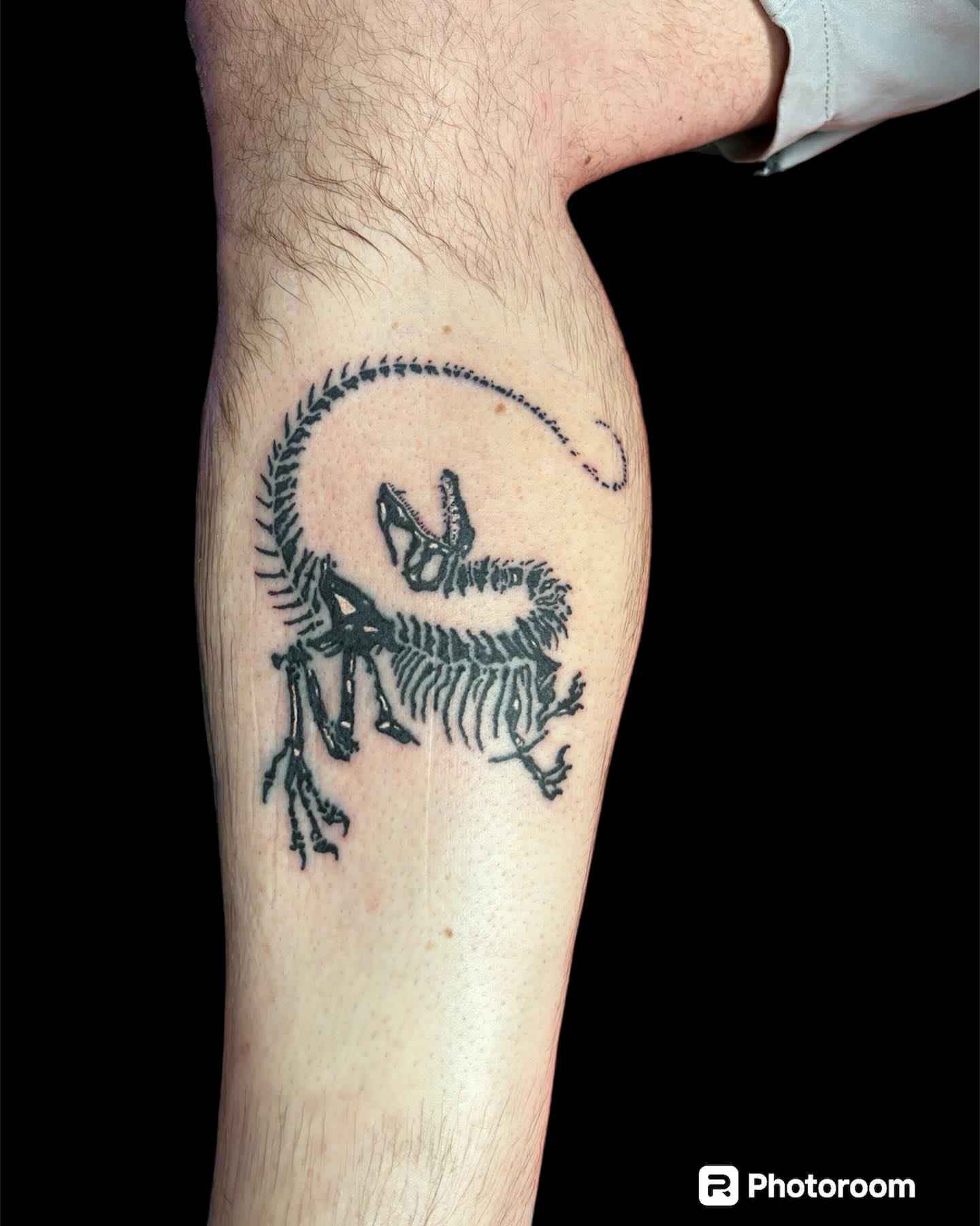 Dinosaur skeleton black and grey tattoo on the forearm by Dale Martin