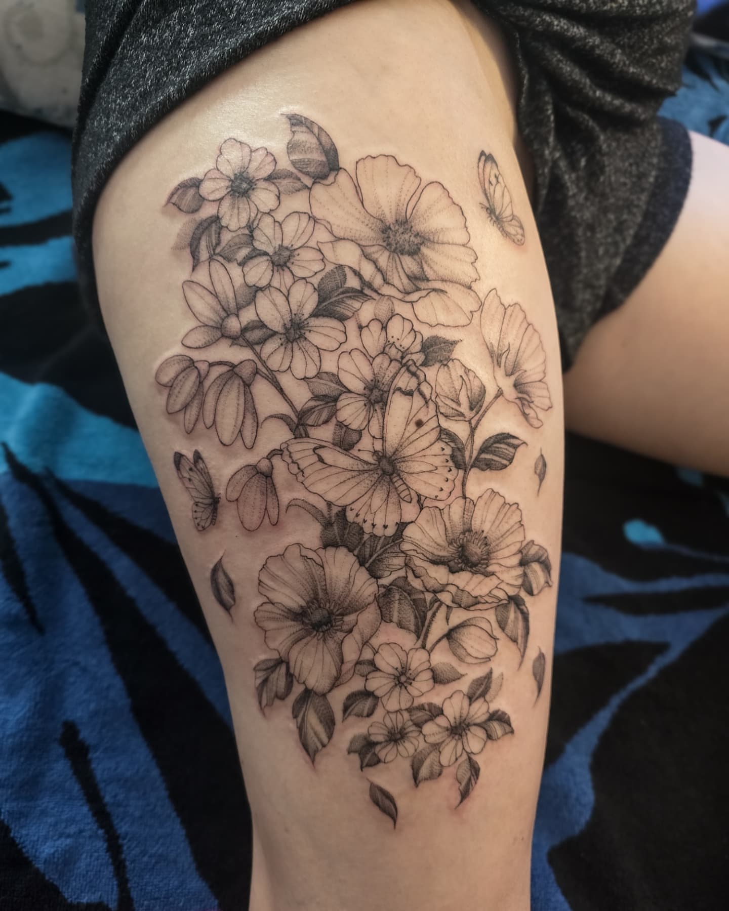 Flowers and butterflies realism tattoo on the thigh by Utah Tattoo Artist