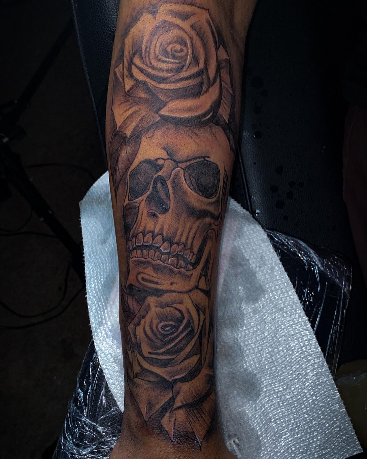 Skull and roses realism tattoo on the forearm by Traveling Tattoo Artist π