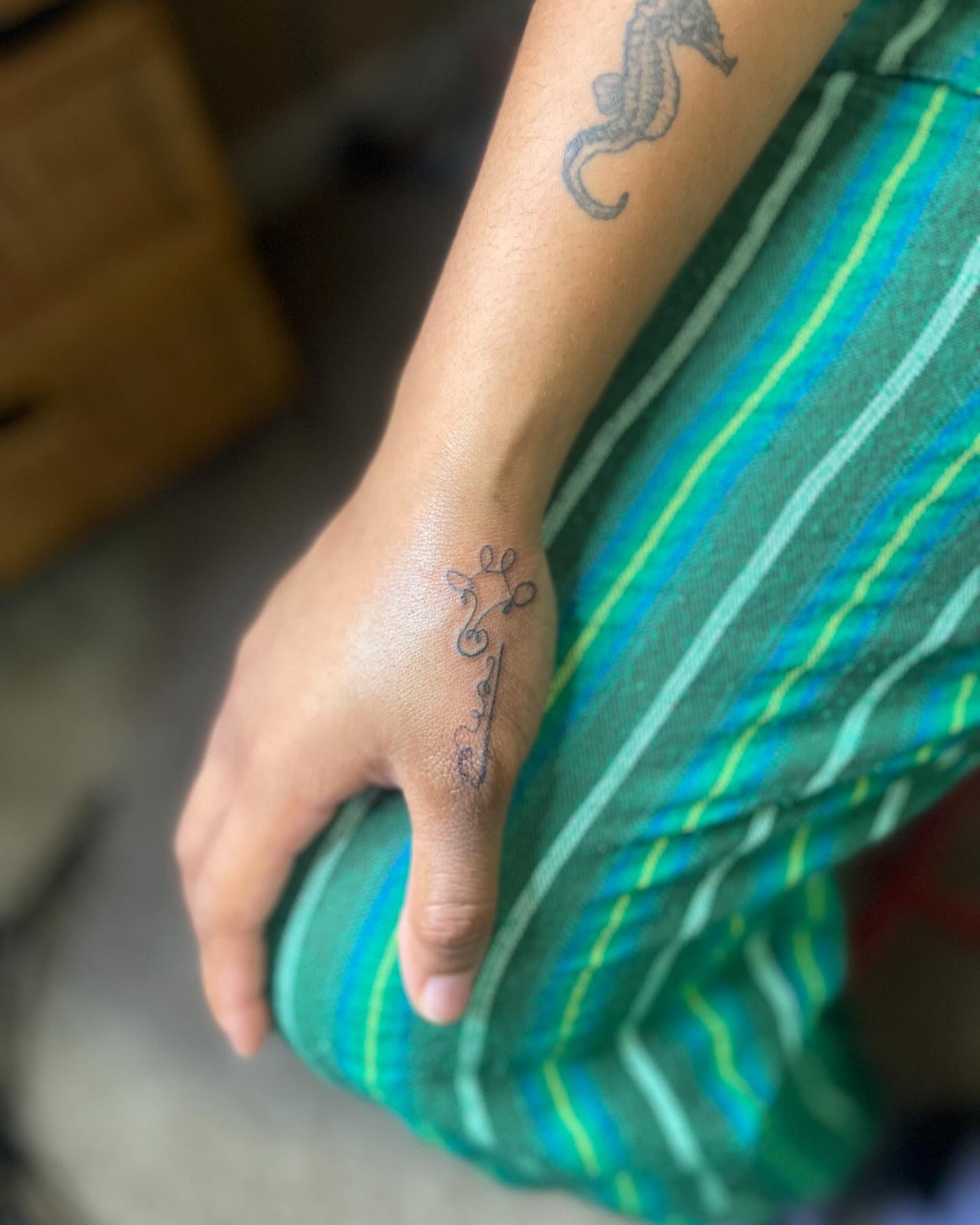 Cross with swirls fine line tattoo on the forearm by Danny Garcia