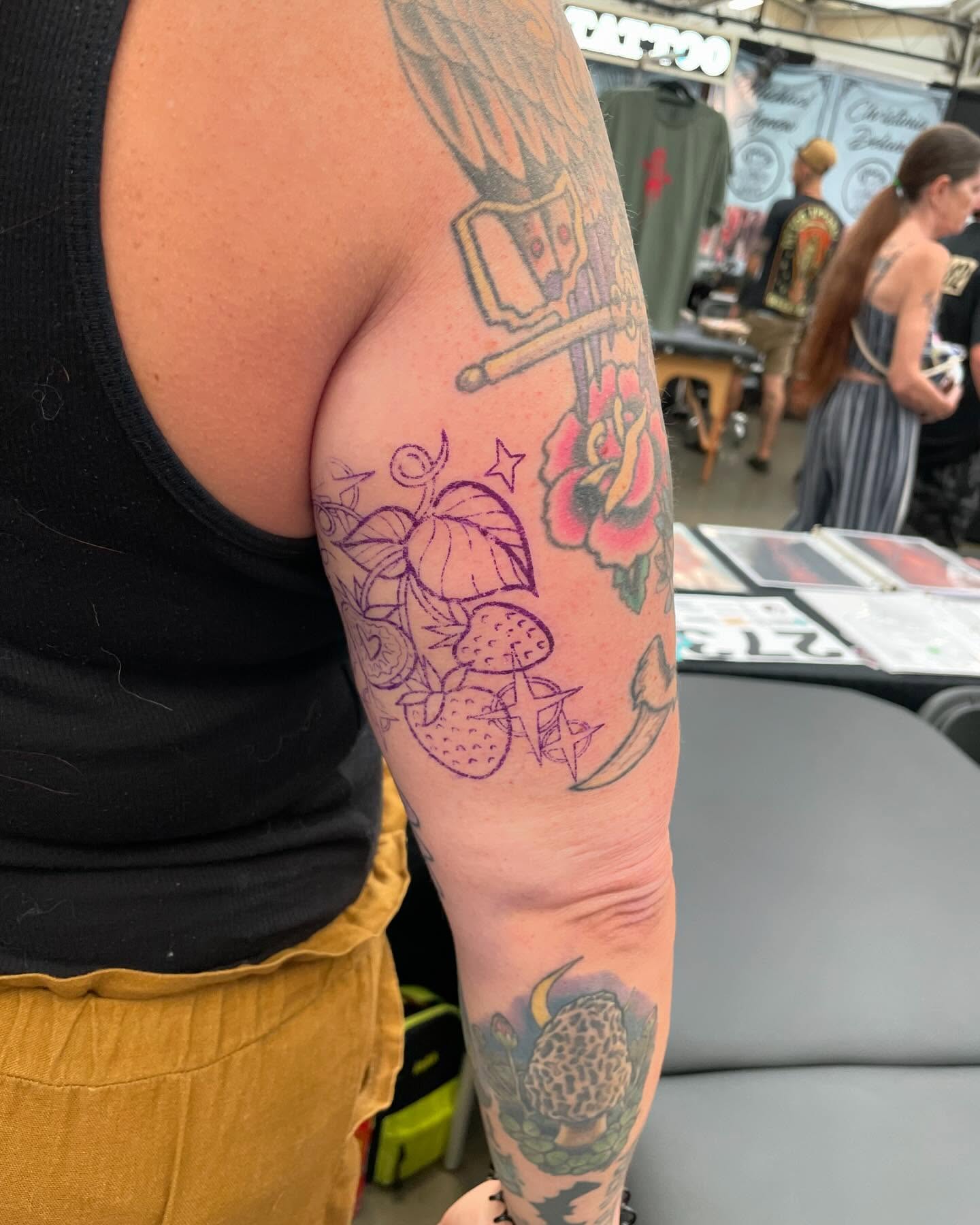 Strawberries and flowers American traditional tattoo on the upper arm by Candence Smith