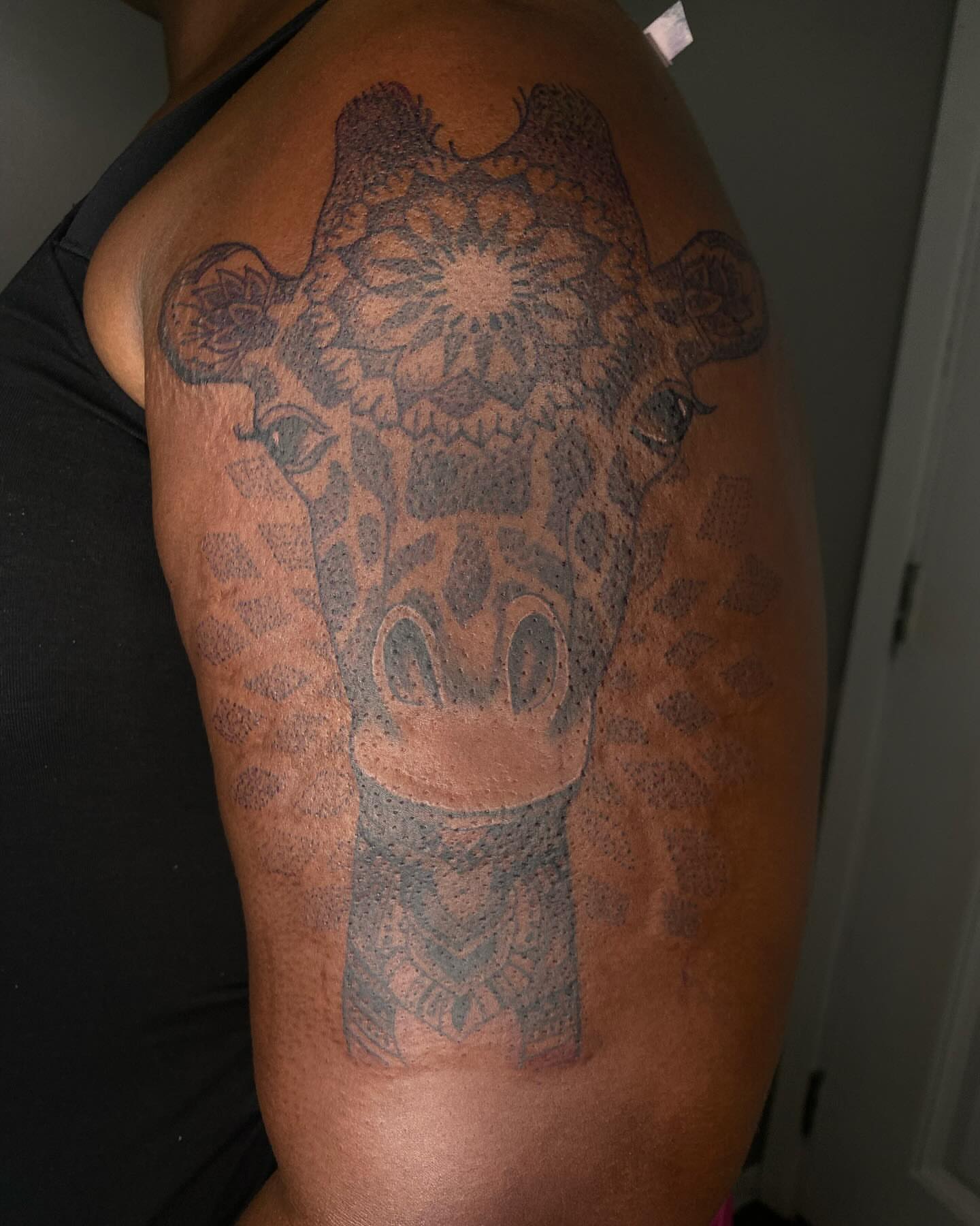 Giraffe dotwork tattoo on the shoulder by Evan Chastain