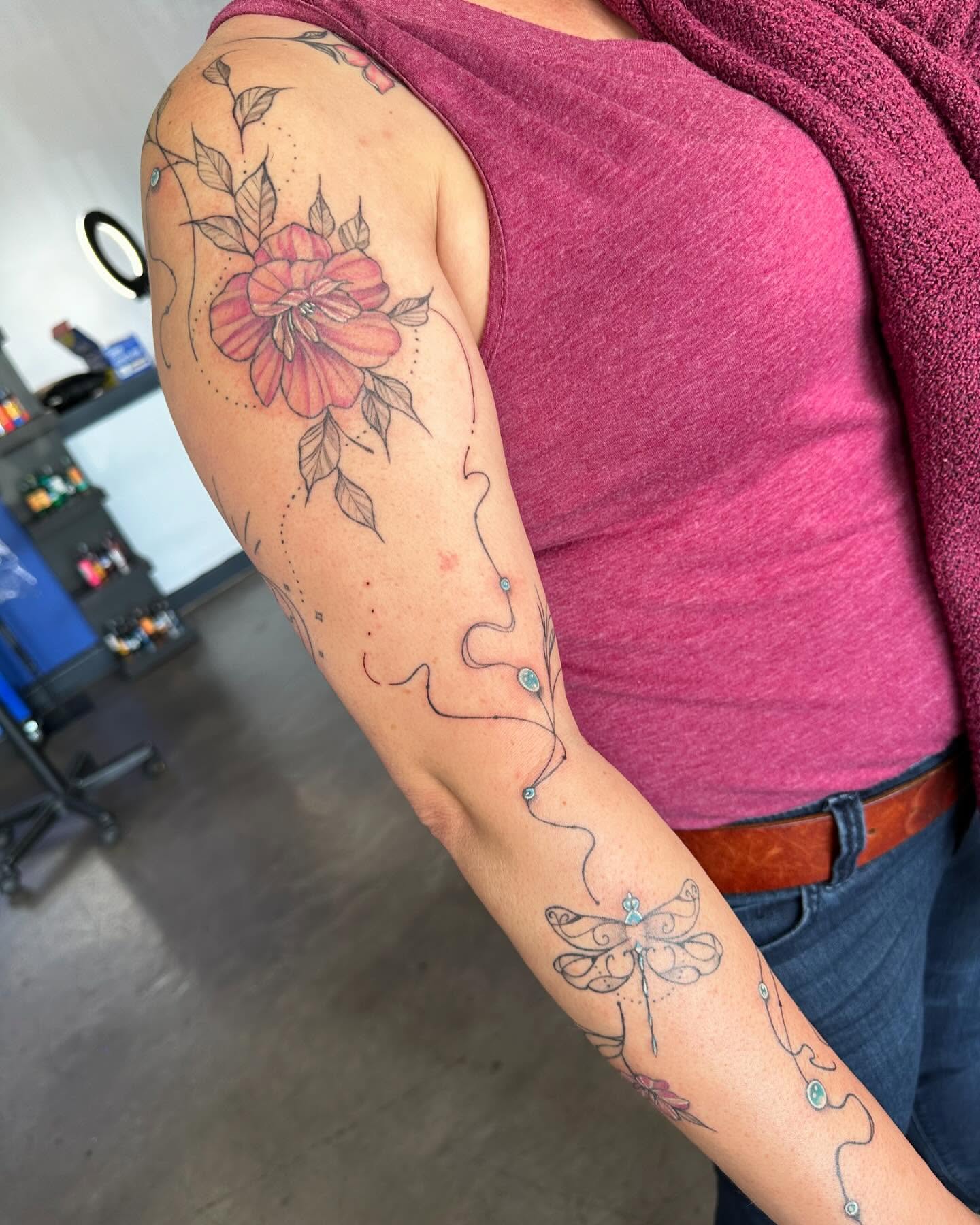 Flower and dragonfly dotwork tattoo on the upper arm by Cameron Hobbs, Woodbridge, Virginia