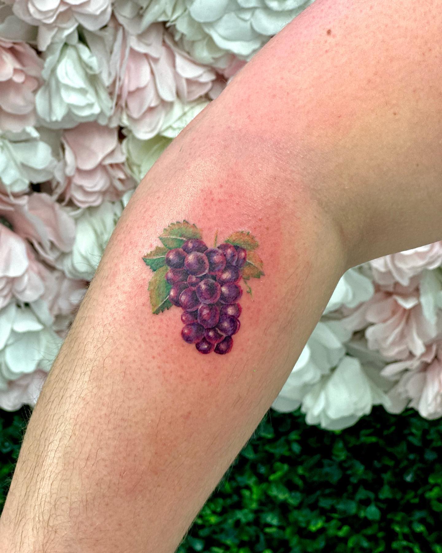 Grapes realism tattoo on the forearm by Erika Nambo