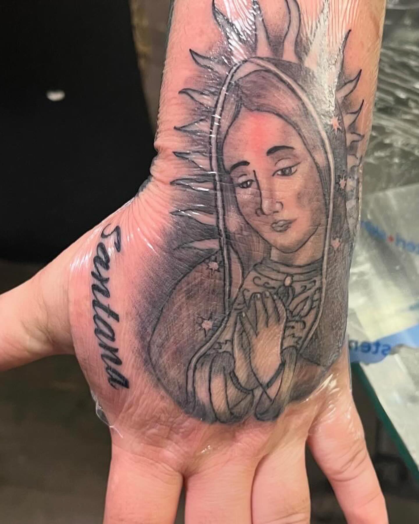 Religious figure black and grey tattoo on the hand by Anna DeLuna