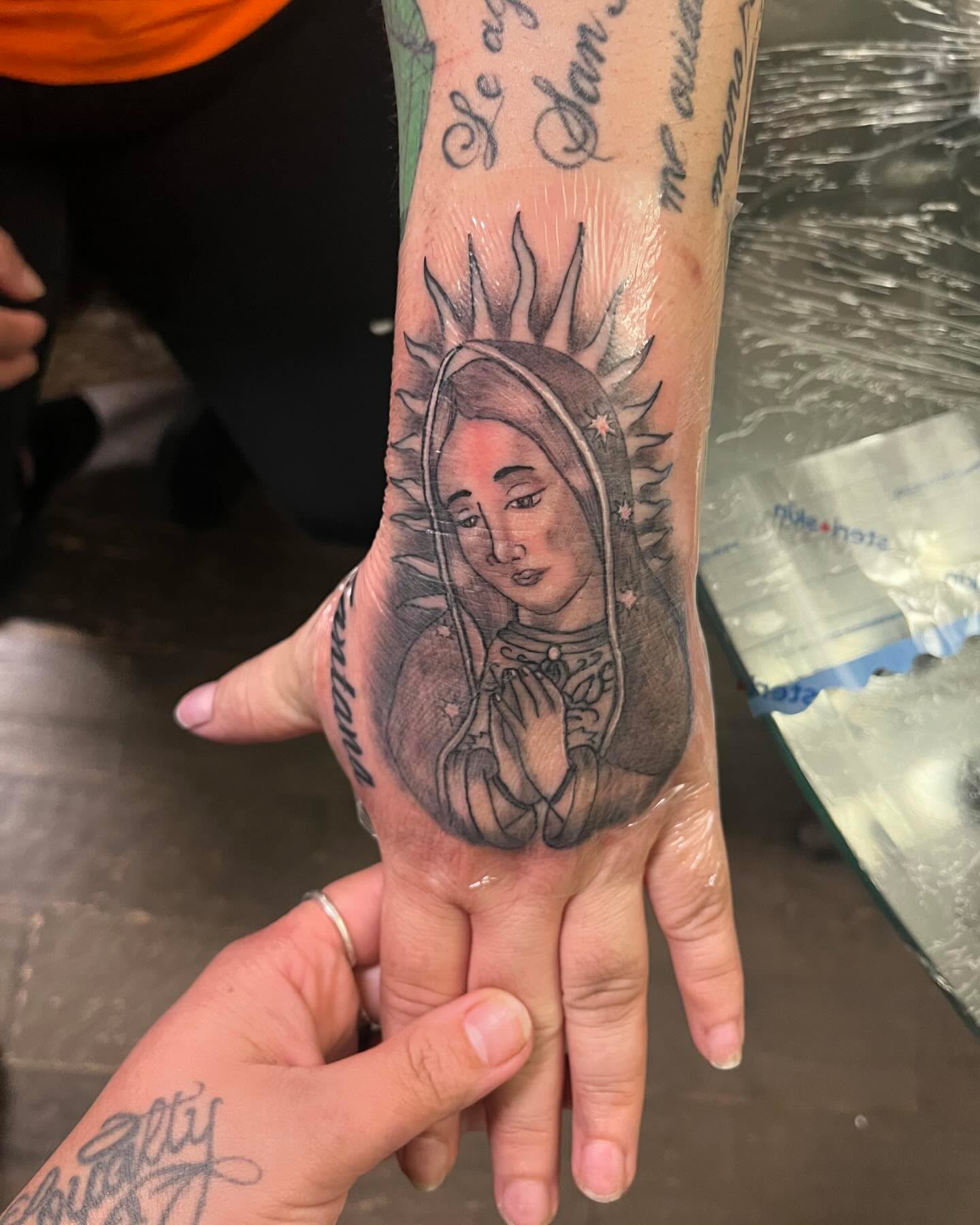 Our Lady of Guadalupe black and grey tattoo on the hand by Anna DeLuna