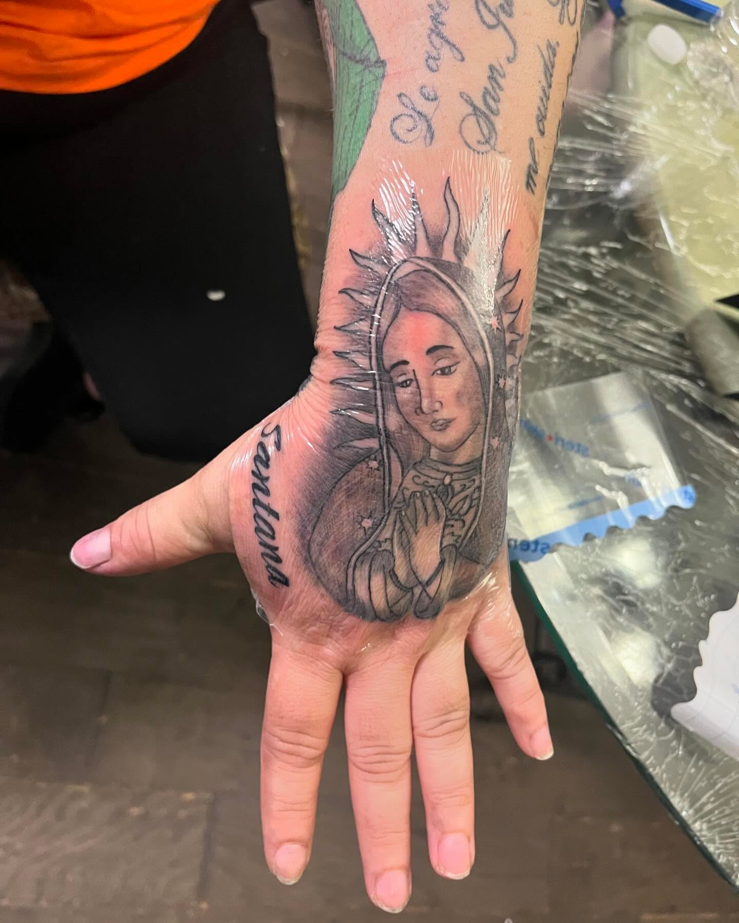 Religious figure black and grey tattoo on the hand by Anna DeLuna